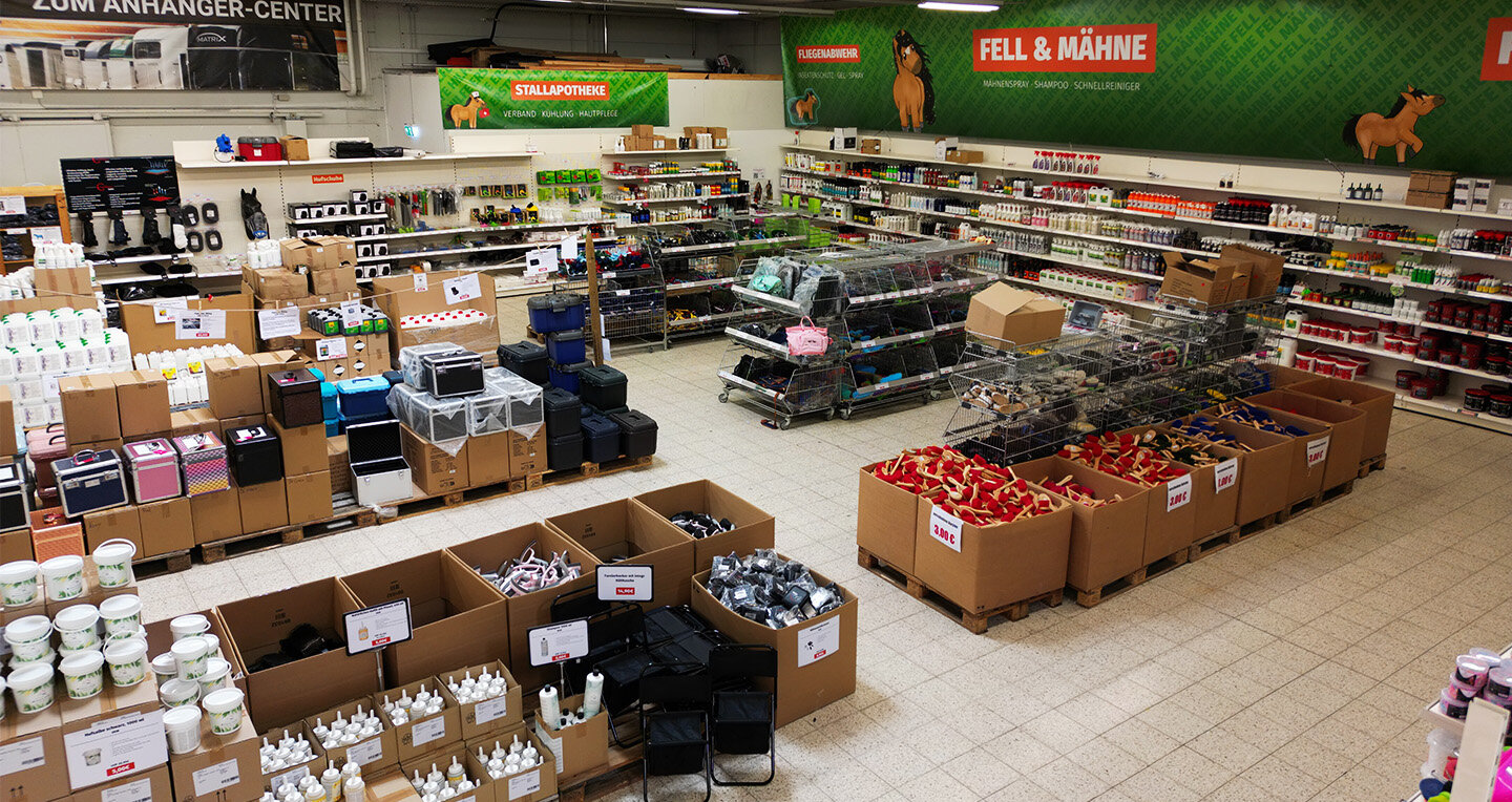 Zu sehen ist die Pflegeabteilung. Regale voller Pflegeprodukte, Gitterkörbe mit Putzzeug und Kartons voller Bürsten.